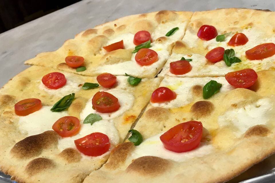 Pizza con pomodorini freschi e basilico, appena sfornata